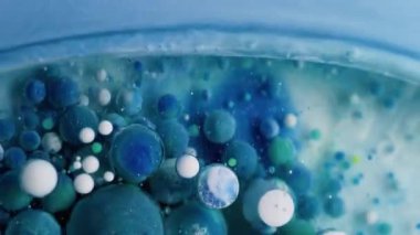 Akrilik baloncuk. Boya karışımı. Renkli jel damlaları su yüzeyinde saydam yuvarlak noktalarda yüzer. Fantezi mavisi soyut sıvı arkaplan.