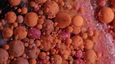 Sanat damlaları. Acryl kabarcığı. Turuncu pembe kıvrımlı köpüklü yağ emülsiyon dokusu. Suyun soyut arka planında renkli mürekkep damlaları.