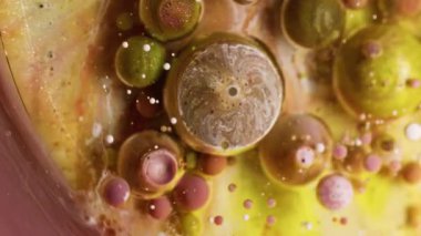 Akrilik baloncuk. Fizzy sıvısı. Bulanık sarı, altın sarısı, pırıl pırıl parlayan boya emülsiyonu yuvarlak, soyut su arka planında yüzen damlacık..