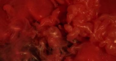 Işıldayan sıvı. Boya girdabı. Parıldayan sanat parçacıkları su akar. Canlı renk emülsiyonu patlaması kırmızı turuncu soyut arkaplan.