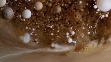 Jel damlası. Boya karışımı. Yağlı boya damlaları suda eriyor. Kahverengi bej beyaz pigment soyut bulanık sanat arkaplanı.