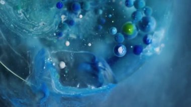 Yağ damlası. Mürekkep su kabarcığı. Çemberin şeffaf renk damlaları mermer mavisi gri sıvı yüzeyde yüzer. Jel parçacıkları soyut arkaplan.