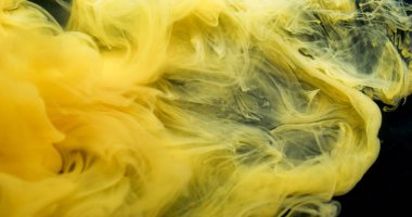 Sis dalgası. Sis mürekkebi kıvrılıyor. Sanatta karıştırılan sarı boya çözünmüş sıvı. Akış rengi pigment kıvrım patlaması soyut siyah arkaplan.