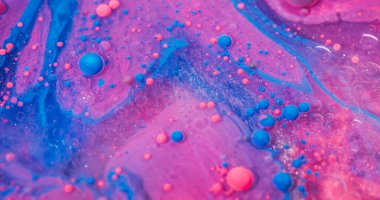 Boya maddesi. Akrilik kütle. Pembe mavi karışımlı sıvı yağ akışı. Işıldayan renkli sanat kabarcığı emülsiyon akışı soyut arkaplanı bulanıklaştırır.