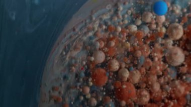 Renkli sıvı. Mermer baloncuklar. Mavi gri akarsu, dönen yağ çemberi. Soyut duman arka planında izole turuncu bej mürekkep damlaları.