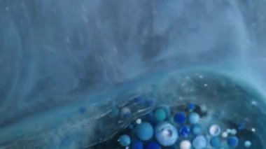 Akrilik küre. Duman sıvısı. Yüzeyde parlayan sisli suda hareket eden büyük şeffaf nokta jel kabarcıkları mürekkebi. Mavi gri köpük soyut arkaplan