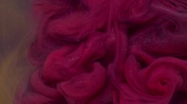 Parlak dalga. Mürekkebi karıştır. Odaklanmamış pembe mor renkli su. Soyut karanlık sanat arka planında parlayan parçacıklar..