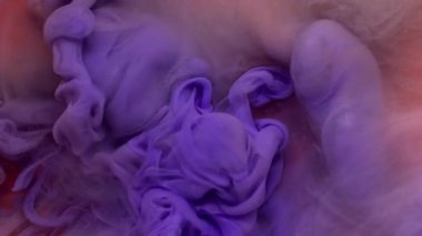 Mürekkep dalgası. Sigara arkaplanı. Odaklanmamış mor turuncu, pembe renkli duman parlatıcı parçacıkları sanat akrilik soyutlaması üzerinde uçuyor..