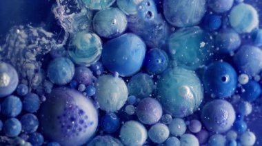 Akrilik daire. Yağ kabarcıkları. Mavi boya damlaları küçük parçacıklarla renkli sıvılarda akar. Yaratıcı sıvı karışımı soyut arka plan köpük yüzeyi.