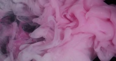 Sis dalgası. Sis mürekkebi kıvrılıyor. Sanatta karıştırılmış pembe beyaz boya çözünmüş sıvı. Hipnotik ışıltılı akış rengi kıvrımlı soyut siyah arkaplan.