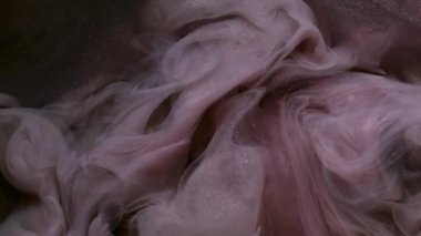 Parlak bir sıvı. Bulut mürekkebi. Odaklanmamış mor simli su egzozu, sanatın parlak dokusu, soyut, karanlık, siyah arka plan..