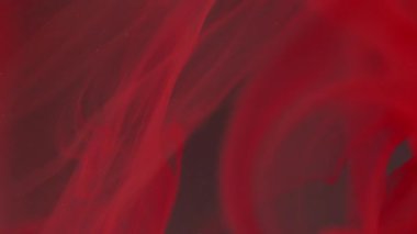 Mürekkep suyu üflüyor. Bulanık boya parlıyor. Odaklanmamış kırmızı renk parlatıcı sıvı damlalar akış sıvısı buhar doku dalgası soyut koyu arkaplan üzerinde.