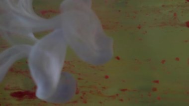 Dikey video. Renk sıvısı düşüyor. Mürekkep suyu karışımı. Odaklanmamış kırmızı mavi parlayan sıvı damlalar soyut ışık arkaplan üzerinde duman dokusu dalgası.