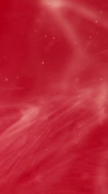 Dikey video. Mürekkep damlası. Duman bulutu. Odaklanmamış kırmızı beyaz renk parıldayan parlak boya soyut sanat arka planında yüzen sıvı damlacık..