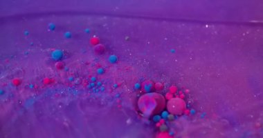 Kabarcık girdabı. Yüzen mürekkep. Pembe mor yağ damlaları ışıldayan parlak sıvılarda akıyor. Çoklu renk karışımı bulanık arkaplan.