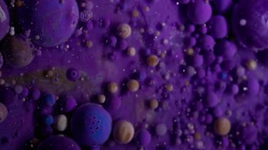 Akrilik leke. Köpüklü sıvı. Renkli sıvı karıştırıcı köpük patlıyor. Dalgalı, menekşe rengi galaksi mermeri, soyut arka plan parıldıyor..