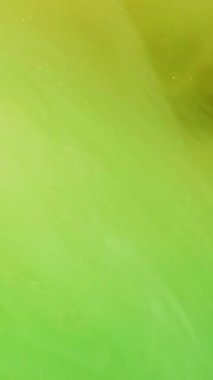 Dikey video. Parlak boya. Renkli karışım. Odaklanamayan parlak yeşil bulut, soyut modern sanat arka planında ilerleyen mürekkep buğusu girdabına sıçrıyor..