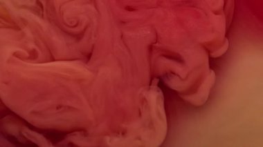 Smog ink. Flow art. Defocused pink orange yellow colorful liquid texture in acrylic water mix cloud soaring on abstract background.