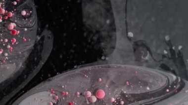 Mürekkep patlaması. Kabarcık emülsiyonu. Kırmızı beyaz boya parçacıkları patlayan yüzey suyu döküyorlar. Sakinleştirici dalga karışım sıvı koyu arkaplan.