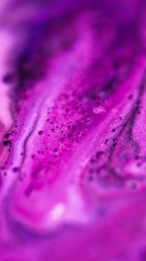 Dikey video. Köpüklü sıvı karışımı. Mürekkep dalgası. Odaklanmamış morumsu pembe renkli yağlı boya karışımı akış akışı soyut sanat arkaplanı.
