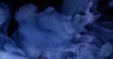Karışık renk girdabı. Sis dalgası. Suyun içindeki çözünmüş mavi boya soyut koyu siyah yaratıcı arka planda akan parlak sıvı..