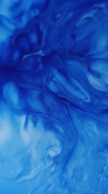 Dikey video. Mürekkep kanıyor. Boya patlaması. Sıvı sanat, kaynamış beyaz mavi dalga emülsiyon parçacıkları diş minesi yüzeyi mermer soyut arka plan döker.