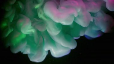 Haze yayıldı. Boya akışı. Işıldayan arka planda yeşil mor sıvı sis dalgası spreyi. Renkli soyut pigment karışımı üfleme bulanıklığı siyah.