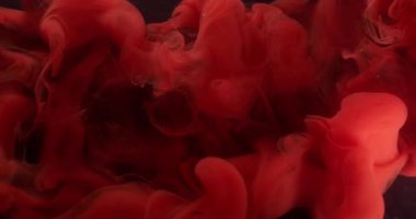 Dalga bulutu. Dönen duman. Odaklanmamış kırmızı renk akrilik boya su ruhani duman dokusu soyut koyu siyah sanat arka planında yüzüyor..