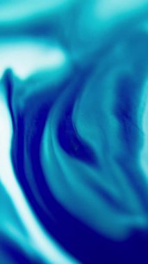 Dikey video. Bulanık boya sıçraması. Deniz dalgası. Odaklanmamış mavi beyaz renk gradyan akrilik mürekkep akışı hareket soyut sanat arkaplanını ortaya çıkarır.