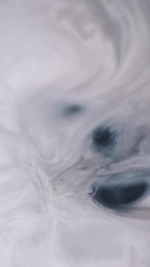 Dikey video. Mürekkep patlaması. Kaynar boya. Sıvı sanat volkanı... beyaz gri siyah emülsiyon... emaye yüzey mermer dokusu... soyut arkaplan açıcı üzerine boya döküyor..