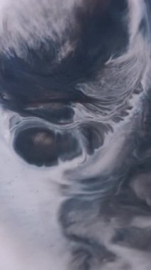 Dikey video. Pigment dökülmüş. Sanat patlaması. Gri, mavi, dağınık, beyaz diş minesi boyası. Soyut lekeli ıslak yüzey çözünmüş kaplama arkaplanı.