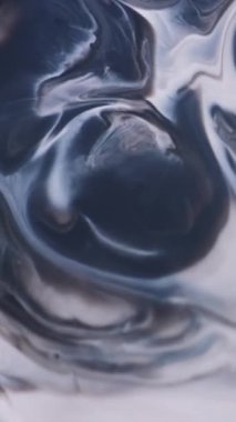 Dikey video. Sanat sıvısı. Boya pigmenti. Odaklanamayan kütle beyaz gri sıvı yüzey yaydı. Kirli sızıntı karışımı kara dalga soyut arkaplanı örtüyor.