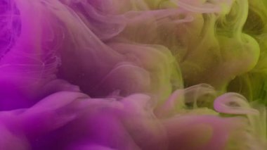 Su altı boyası. Haze girdabı. Soyut sıvıda sarı mor akış mürekkebi. Fantezi çözülmüş renk damlası karışımı koyu arkaplanda.