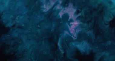 Mürekkebi karıştır. Soyut lekeler. Odaklanmamış mavi renk akışı su sıvısı parlak parçacıklar sanatın karanlık arka planına yayılıyor..