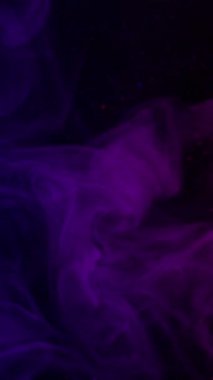 Dikey video. Çok renkli mürekkep. Duman spreyi. Mor mor kabarcıklar koyu sularda yayılıyor. Parlak odaklı soyut gece dokusu arkaplanı.