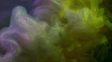 Buhar dokusu. Parıltı akıyor. Renkli spektrum dumanı, siyah arka planda mürekkep akışını karıştırıyor. Işıldayan sarı yeşil boya soyut girdap.