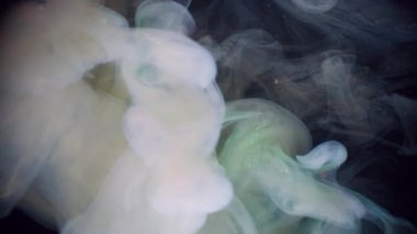 Buhar bulutu. Köpüklü sıvı. Siyah arka planda beyaz sarı duman spreyi fırtınası. Renkli sıvı boya soyut bulanıklık suya sıçrar.