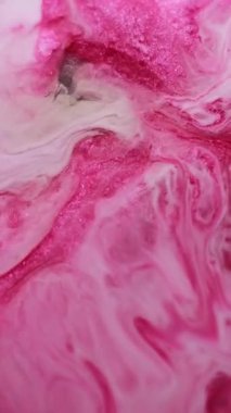 Dikey video. Işıl ışıl. Boya karışımı. Pembe beyaz mermer sıvı genişleme ıslak soyut arka plan yüzeyi. Parıldayan odaklanmış ciladan emülsiyon.