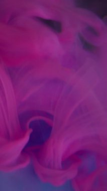 Dikey video. Mistik duman. Hipnoz sıvısı. Pembe mor kıvrımlı boya cam üzerinde süzülüyor mavi kristal elmas su çözülmüş soyut arkaplan.