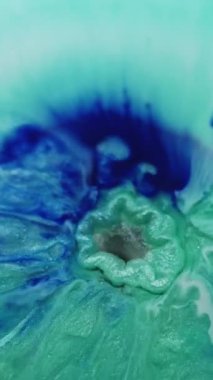 Dikey video. Parıltı dökülüyor. Sıvı patlaması. Gümüş rengi kara delik garip bir dalga mavi turkuaz boya dolduruyor. Mermer karıştırıcı ışıltılı pigment soyut arkaplan.
