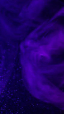 Dikey video. Puf boyası. Duman patlaması. Mor mavi çekim dalgası sanatsal emülsiyon yayıyor. Renkli su soyut arkaplan bulanıklığı titreşimi.