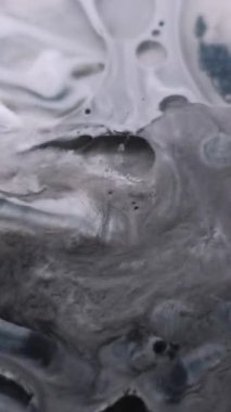 Dikey video. Mürekkep döküldü. Köpük sıvısı. Yağlı akrilik suluboya sanat sıvısı karışım dalgası pürüzsüz doku. Grunge gri siyah beyaz parçacıkları soyut arkaplan yüzeyi.