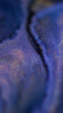 Dikey video. Köpüklü sıvı sıçraması. Mürekkep karışımı. Odaklanmamış mavi siyah renk parıldayan parçacıklar boya akış hareketi soyut sanat arkaplanı.