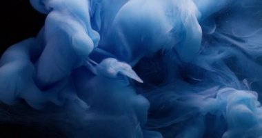 Su sıçraması. Sis dalgası. Sıvı dumanlı akrilik dokuda dönen çözünmüş mavi renkli boya soyut koyu siyah arka planda asılı duruyor..