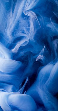 Su sıçraması. Sis dalgası. Sıvı dumanlı akrilik dokuda dönen çözünmüş mavi renkli boya soyut koyu siyah arka planda asılı duruyor..