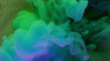 Haze yayıldı. Boya akışı. Mor arka planda mavi yeşil sıvı sis dalgası spreyi. Renkli neon rengi soyut pigment karışımı bulanık üfleme.