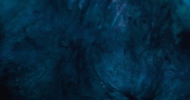 Parlak mürekkep. Dalgalanma dokusu. Odaklanmamış mavi mor renkli su parlatıcı sıvı yuvarlak lekeler soyut sanat arka planına yayılıyor.