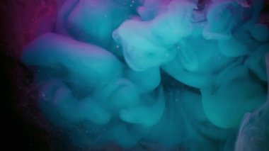 Puslu sanat patlaması. Renkli sis. Siyah arka planda mavi mor bir girdap var. Mürekkep karışımı parlayan parçacıklar odaklanmış sanat sıvısı.