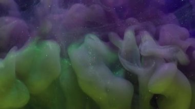 Puslu sanat patlaması. Renkli sis. Siyah arka planda yeşil mor bir girdap var. Mürekkep karışımı titreşen parçacıklar çözünmüş sıvı.