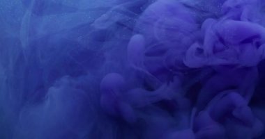 Parçacıklar sıçrar. Dönen duman. Odaklanmamış mavi renk boya akrilik su ruhani duman dokusu soyut koyu siyah arkaplanda yüzüyor..